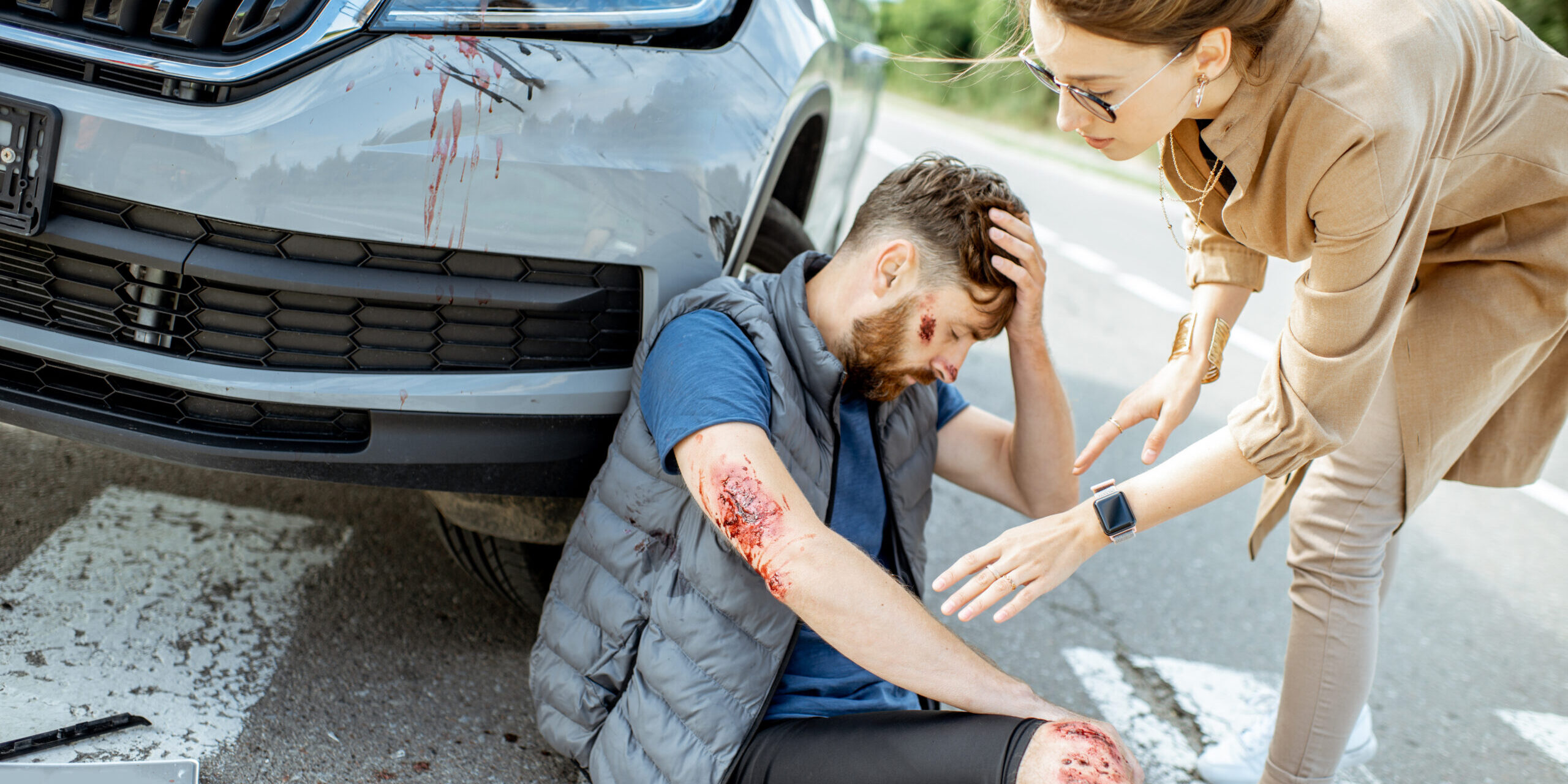 Woman driver with injured man on the road